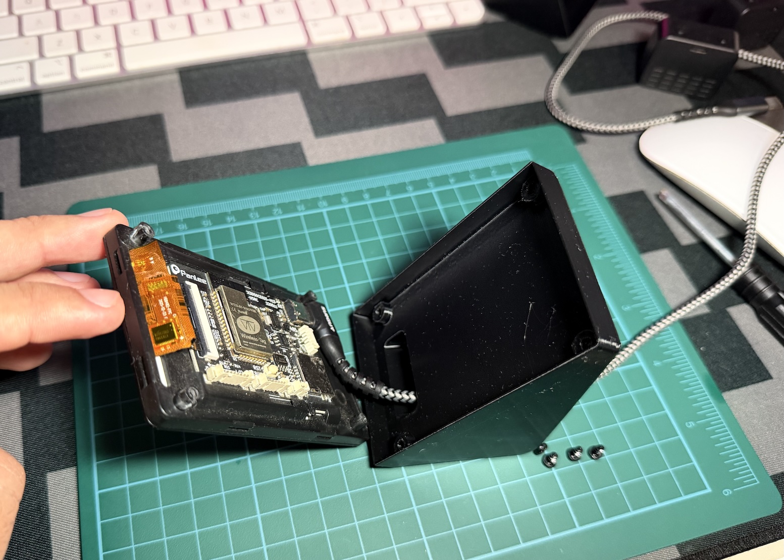 The right-angle end of the cable plugged into the board, the cable routed through the stand's slot